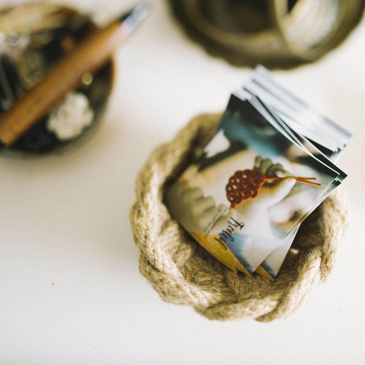 Stack of travel safety product brochures in a woven basket on white table, Kontenl store